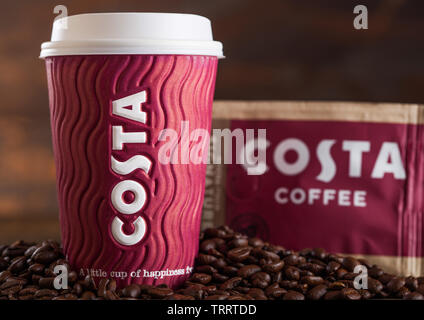 LONDON, UK - Juni 05, 2019: Costa Coffee Pappbecher mit pack Original Costa Coffee mit Bohnen auf Holz. Stockfoto