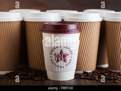 LONDON, UK - Juni 05, 2019: Pret A Manger/Pappbecher für Weg mit Kaffeebohnen auf hölzernen Hintergrund mit braunen Kaffeetassen nehmen. Stockfoto