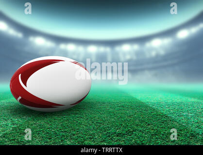 Eine reguar Weiß rugby ball mit roten Design Elemente auf ein Stadion rasen in der Nacht ruht unter beleuchtet Fluter - 3D-Rendering Stockfoto