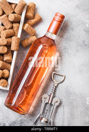 Flasche und Gläser pink rose Wein mit Box von Korken und Korkenzieher Dosenöffner auf Stein Küchentisch Hintergrund Stockfoto