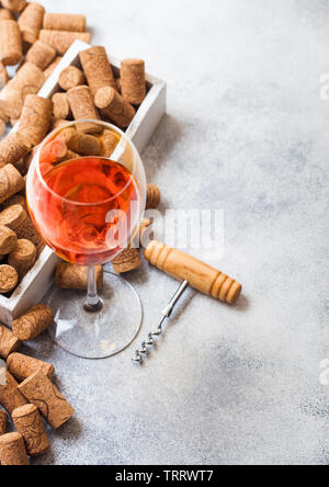 Glas rosa Rose Wein mit Box von Korken und Korkenzieher Dosenöffner auf Stein Küchentisch Hintergrund. Ansicht von oben. Stockfoto