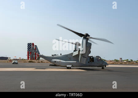 Ein U.S. Marine Corps MV-22 B Osprey mit Marine Medium Tiltrotor Squadron (VMM) 264 (verstärkt), Marine Aircraft Group (MAG) 26, 2. Marine Flugzeugflügel (MAW), 22 Marine Expeditionary Unit (MEU) zu den San Antonio-Klasse amphibious Transport dock Schiff USS Arlington LPD (24) auf der Flucht line kommt vor dem Passagier Transfer an Lager Lemonnier, Dschibuti, 7. Juni 2019. Camp Lemonnier ist ein operativ-fokussierte Ufer installation, USA ermöglicht, Verbündeten und Partner nation Kräfte zu, wo und wann sie benötigt, Sicherheit und Stabilität in Europa, Afrika und im Südwesten, um sicherzustellen, dass die Stockfoto