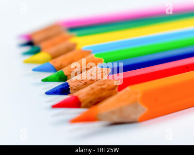 Statt Masse Konzept. Bündel der sortierten multi Buntstifte Buntstifte in Rainbow Anordnung auf weißem Hintergrund, flach. Geometrie pa Stockfoto
