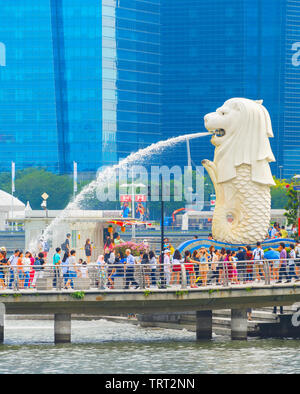 Singapur - Januar 14, 2017: Masse der Touristen durch Singapur Löwenbrunnen und Glasfassaden der Wolkenkratzer im Hintergrund Stockfoto