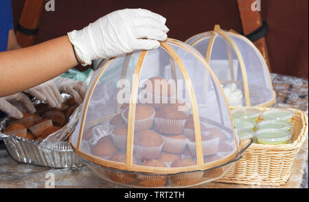 Verkäuferin begradigt Muffins auf Glas Fach während der Prager Botschaft Street Food Festival. Stockfoto