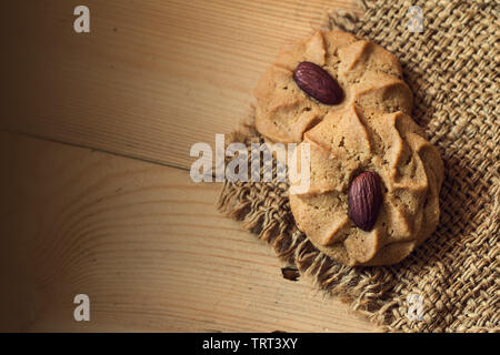 Almond Cookies mit Mandel- Muttern auf hölzernen Tisch Hintergrund mit Platz für Text Stockfoto