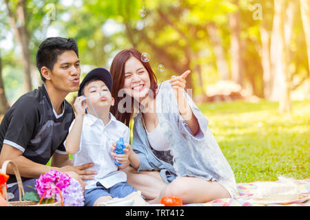 Asiatische Familie Spielen Bubble zusammen im Green Park Natur Hintergrund