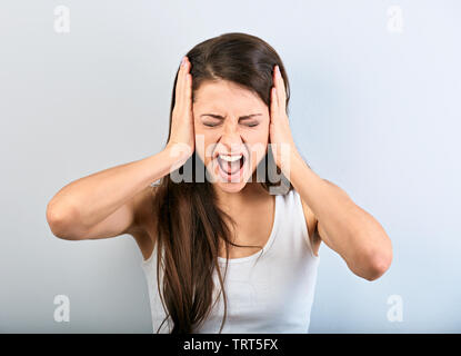 Young Business Frau starke wild schreiend mit offenen Mund und halten die Hände auf blauem Hintergrund Zorn. Nahaufnahme Stockfoto