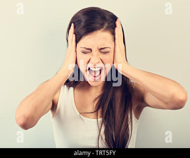 Young Business Frau starke wild schreiend mit offenen Mund und halten die Hände auf blauem Hintergrund Zorn. Closeup getönten Portrait Stockfoto