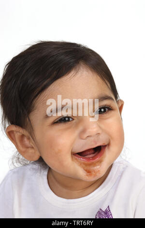 Nahaufnahme von einem Babymädchen mit Schokolade auf Gesicht Stockfoto