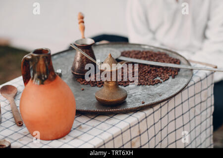 Die Türkischen arabischen Kaffee in den Sand in jezve Stockfoto