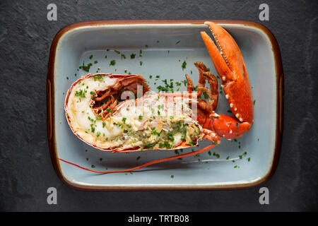 Eine halbe gegrillten Hummer und Klaue aus einem Hummer Homarus gammarus, in einem Lobster Pot im Ärmelkanal gefangen. Es hat zuerst gekocht, dann Split Stockfoto