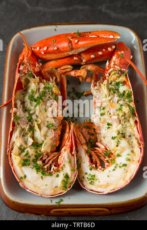 Zwei Hälften eines gegrillten Hummer und Krallen aus einem Hummer Homarus gammarus, in einem Lobster Pot im Ärmelkanal gefangen. Es hat zuerst gekocht, Stockfoto