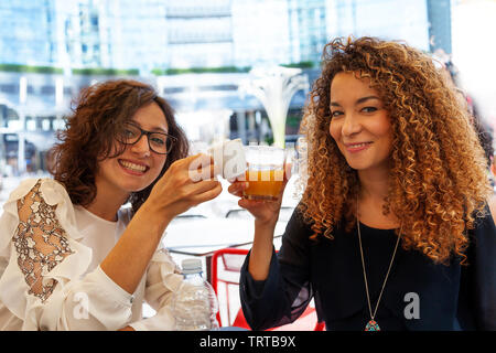 Zwei adorable Mädchen lächelnd während Toasten sitzen in einem Café im Herzen der Hauptstadt Stockfoto