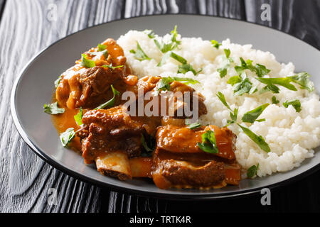 Beef Ribs in pikanter Soße mit Reis garnieren Close-up auf einem Teller auf den Tisch. Horizontale Stockfoto