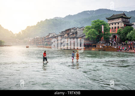 2. Juni 2019, Fenghuang China: Chinesische Touristen auf Stepping-stone bridge und alte Häuser am frühen Morgen in Phoenix, antike Stadt in Hunan in China Stockfoto