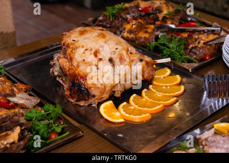 Gebackene Schweinshaxe auf einem Tablett auf den Tisch im Restaurant Stockfoto