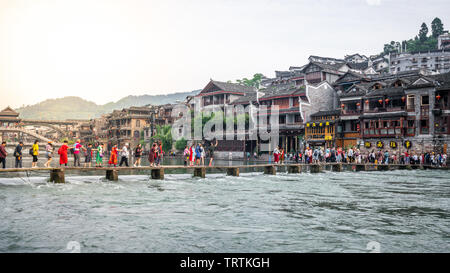 2. Juni 2019, Fenghuang China: Chinesische Touristen auf Brücke über Tuo Jiang River und alten Festung im Hintergrund in Phoenix, antike Stadt in Hunan Ch Stockfoto