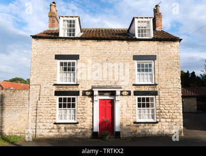 Ein denkmalgeschütztes Freistehendes Steinhaus, Dossers Haus, auf dem Grün in Slingsby, North Yorkshire, England, Großbritannien Stockfoto