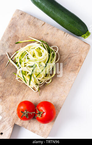 Gesunde Ernährung Konzept Vorbereitung Guilten-Free Zucchini Nudeln Pasta in Holz- Board Stockfoto