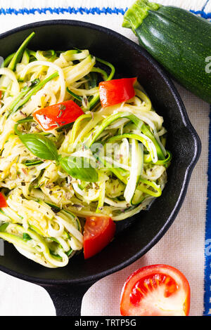 Gesunde Ernährung Konzept hausgemachte Guilten-Free Zucchini Nudeln, Pasta mit Tomaten in Iron skillet Pan Stockfoto