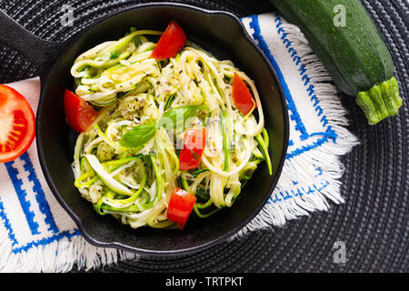 Gesunde Ernährung Konzept hausgemachte Guilten-Free Zucchini Nudeln, Pasta mit Tomaten in Iron skillet Pan Stockfoto