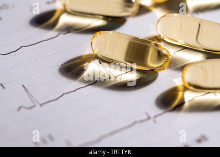 Elektrokardiogramm und Omega 3 Pillen. Konzept gesundes Herz Stockfoto