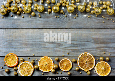 Weihnachten Zusammensetzung mit Orangenscheiben, Golden Lights, golden glitter Kugeln und weiße Sterne auf Holz- Hintergrund - Platz für Text Stockfoto