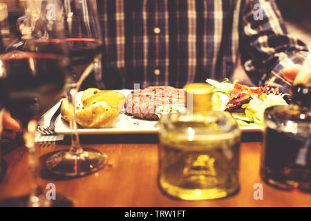 Blick auf Tabelle mit Treffen Burger und Salat zum Abendessen in einem Restaurant Stockfoto