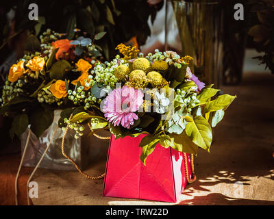 In der Nähe der lebendigen Blumen in farbigen papper Tasche zu geben Stockfoto