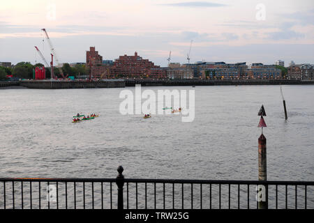 Menschen in Kajaks auf der Themse paddeln auf Limehouse Waterfront Apartments am Nordufer der Themse in England UK KATHY DEWITT Stockfoto