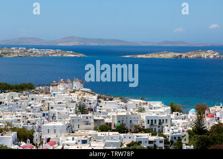 Blick auf die Küste von Mykonos, Griechenland und die Ägäis von oben die weiß getünchte Stadt und die berühmten Windmühlen. An einem sonnigen Nachmittag im Mai. Stockfoto