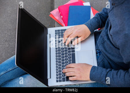 Studenten mit Laptop und Bücher lernen für die Prüfung auf dem Campus Treppe. Schüler mit kostenfreiem Internetzugang Auf dem Campus im Sitzen. Konzept Stockfoto