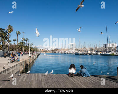 BARCELONA, Spanien - 3. MÄRZ 2019: Zwei weibliche Touristen Rest von Möwen im Alten Hafen der Stadt Barcelona umgeben. Katalonien, Spanien. Stockfoto