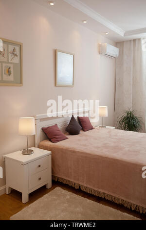 Epmty minimalistischen Interieur Hintergrund, Schlafzimmer, modernes Apartment mit Doppelbett, Lichter auf, niemand, mit Kopie Raum, vertikal Stockfoto