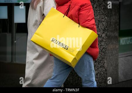 Eine Frau, die ein Selfridges Papier Karte Tragetasche Stockfoto