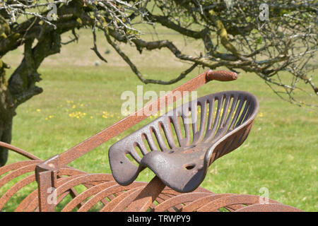 Sitz und heben Sie den Hebel auf dem Heu rechen im Ruhestand in ein Feld auf Exmoor, umgerechnet von Pferden gezogenen am Traktor angetrieben. Exford, Somerset UK Stockfoto