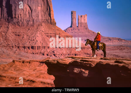 Navajo Mann zu Pferd im Navajo Tribal Park, Arizona und Utah. Bunte Sandstein Buttes. Stockfoto