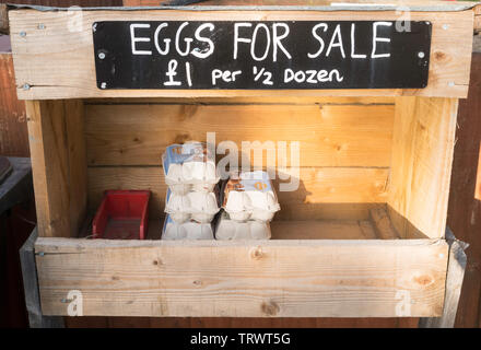 Den Abschaltdruck am Straßenrand verkaufen Eier aus Freilandhaltung mit einem Honesty Box für Zahlung in Fryton, North Yorkshire, England, Großbritannien Stockfoto