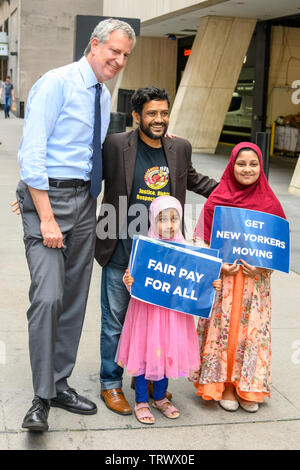 New York, USA, 12. Juni 2019. New York City Bürgermeister Bill De Blasio stellt mit einem Mitglied eines Taxi drivers' Union und seine Familie nach der Ankündigung eine Ausweitung der GAP auf die FHV (For-Hire Fahrzeuge). Credit: Enrique Ufer/Alamy leben Nachrichten Stockfoto