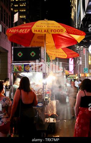 Leute an einem Halal Warenkorb in New York City bei Nacht Stockfoto