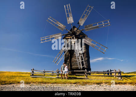 Paar Tourist in der Nähe von alten traditionellen Wind Mill in Nationale Architektur Museum in Pirogowo, Kiew, Ukraine posing Stockfoto