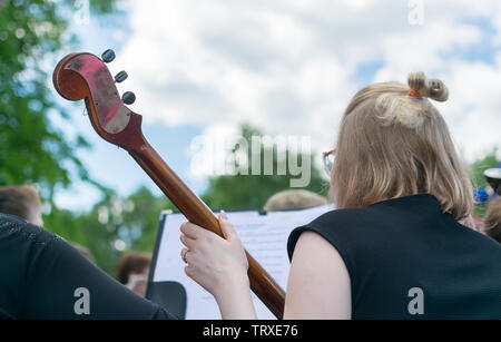 Mädchen an einer Straße Konzert im Freien spielen der Kontrabass, ein Musikinstrument, Notebook mit Notizen Stockfoto