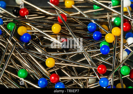 Stahl mit Pins/Pins zum Nähen, in einem Kasten mit bunten Kunststoff Kugelköpfe. Die extreme Makro ermöglicht die Fähigkeit der polnischen und t zu sehen Stockfoto