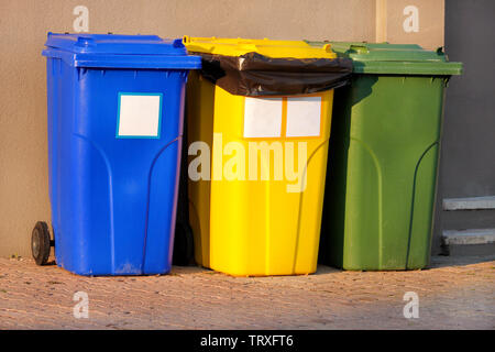 Mülleimer, Mülleimer, Papierkorb in Ferienanlage Resort, Warten von Müllwagen abgeholt zu werden. Blau, Gelb und Grün Behälter für Abfälle. Stockfoto