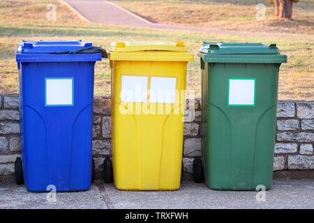 Mülleimer, Mülleimer, Papierkorb in Ferienanlage Resort, Warten von Müllwagen abgeholt zu werden. Blau, Gelb und Grün Behälter für Abfälle. Stockfoto