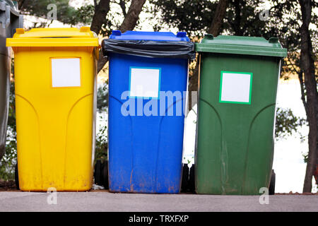 Mülleimer, Mülleimer, Papierkorb in Ferienanlage Resort, Warten von Müllwagen abgeholt zu werden. Blau, Gelb und Grün Behälter für Abfälle. Stockfoto