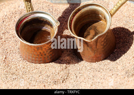 Zubereitung der traditionellen türkischen Kaffee in cezve auf heißem Sand Stockfoto