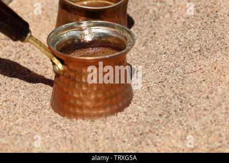 Zubereitung der traditionellen türkischen Kaffee in cezve auf heißem Sand Stockfoto