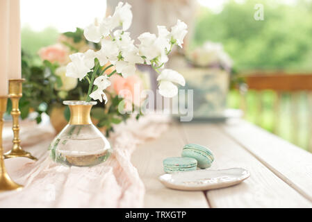 Tabelle für Gäste, mit Kerzen geschmückt, serviert mit Geschirr und Besteck sowie mit einer Tischdecke blau Platte und goldenen Gabel und Messer auf Rosa abgedeckt Stockfoto
